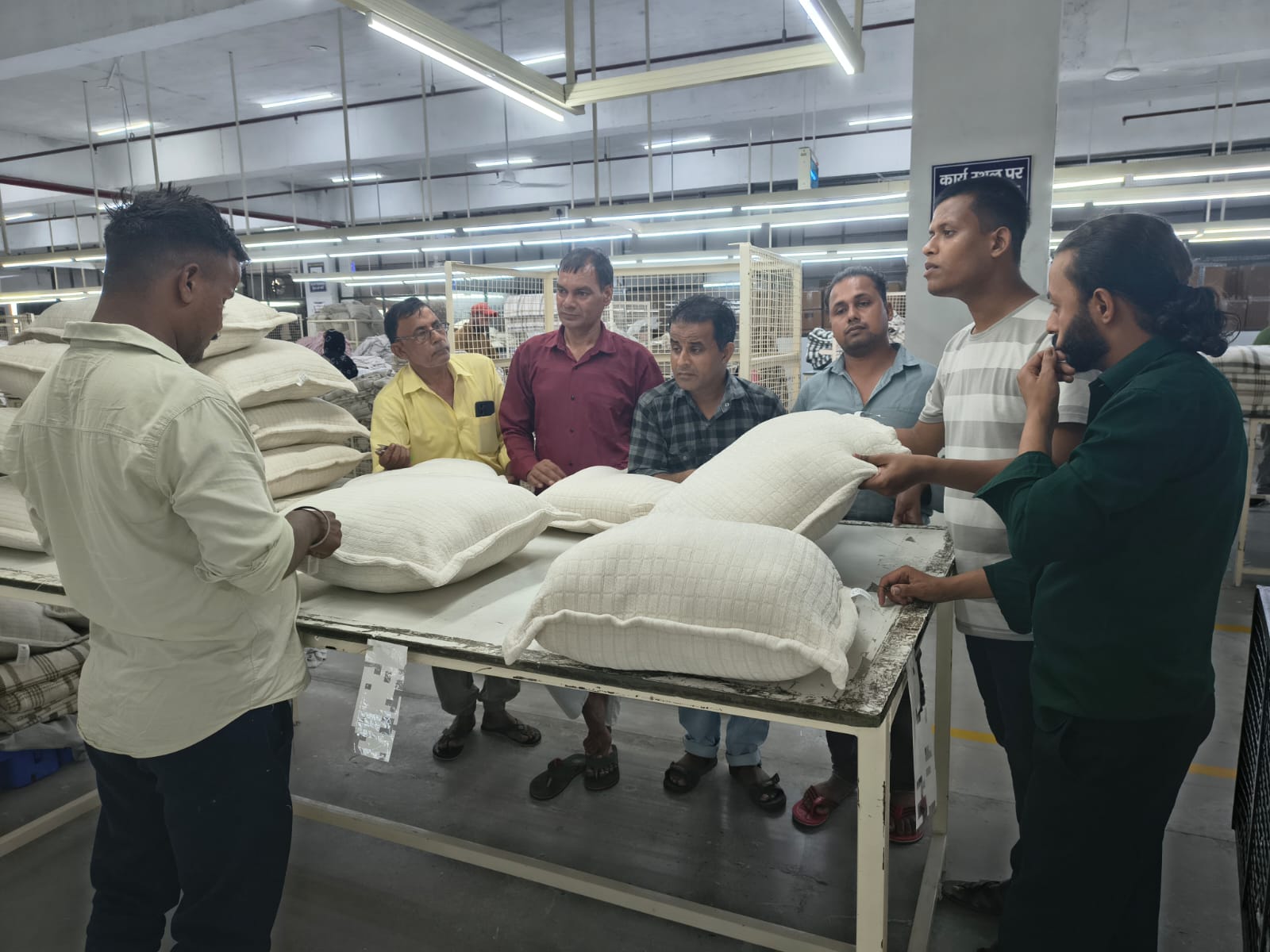 Quality team inspecting finished cushions on a checking table